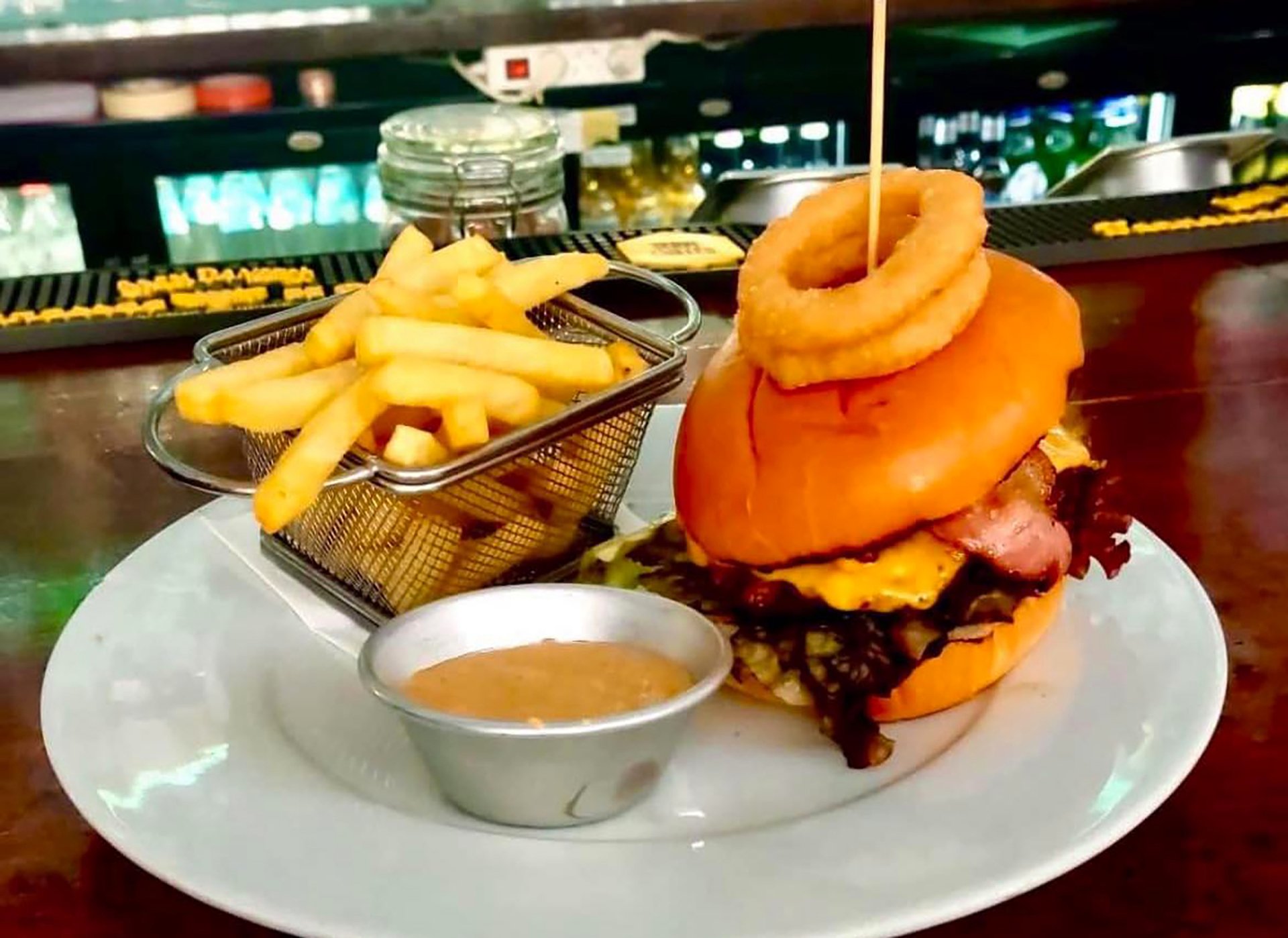 A loaded burger with onion rings and fries at the Oscars bar